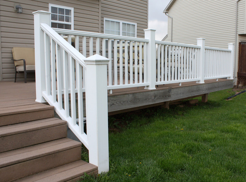 New deck featuring newly painted white railing at a home in Kenosha