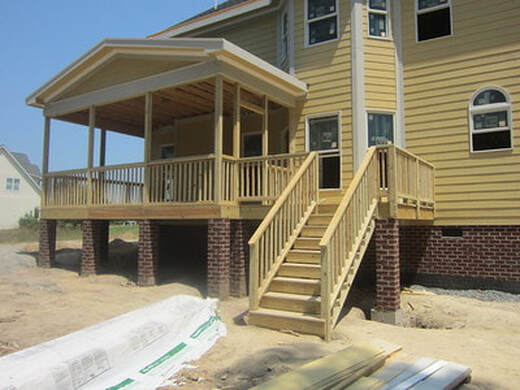 New deck built in Kenosha County. Yellow home with a raised deck.
