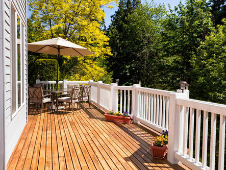 Upper level of deck with patio seating and umbrella above for covering.